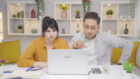 The-couple-reacting-negatively-to-what-they-see-on-the-laptop.